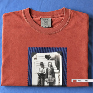 Brick colored folded t-shirt with small black and white vintage 1920's photo of kids posing for a shot