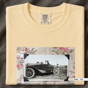 Butter colored folded t-shirt with large vintage snapshot of people riding in a 1920's car surrounded by a floral design.