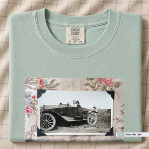 Chalky Mint colored folded t-shirt with large vintage snapshot of people riding in a 1920's car surrounded by a floral design.