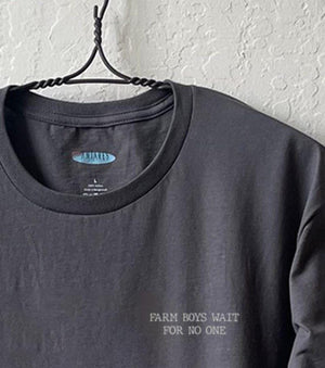 Close up shot of collage art t-shirt with tagline on front: 'Farm Boys Wait For No One'