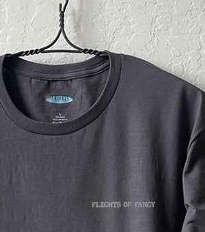 Close up shot of collage art t-shirt with tagline on front: 'Flights of fancy'