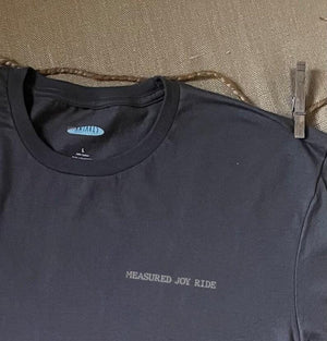 Close up shot of collage art t-shirt with tagline on front: 'Measured Joy Ride'