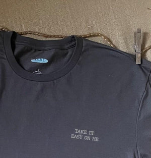 Close up shot of collage art t-shirt with tagline on front: 'Take It Easy On Me'