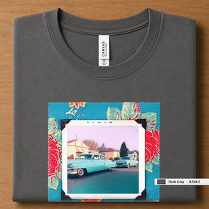 Dark Grey colored folded t-shirt with large a vintage photo of two classic 50's cars on the street. Photo is surrounded by floral fabric.