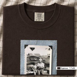 Espresso colored folded t-shirt with a large vintage photo of a father and his son sitting on the bumper of an old car.