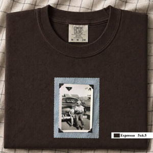 Espresso colored folded t-shirt with a small vintage photo of a father and his son sitting on the bumper of an old car.