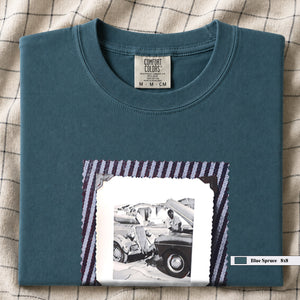 Folded Blue Spruce t-shirt with a large vintage photo of mechanics and cars on front of shirt.
