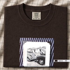 Folded Dark Brown or Espresso t-shirt with a large vintage photo of mechanics and cars on front of shirt.