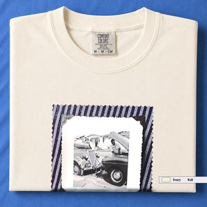 Folded Ivory t-shirt with a large vintage photo of mechanics and cars on front of shirt.