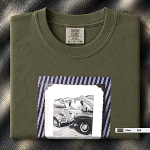 Folded Moss t-shirt with a large vintage photo of mechanics and cars on front of shirt.