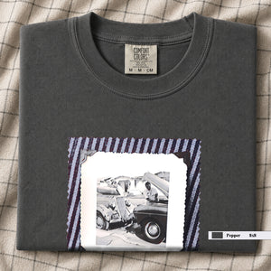 Folded Pepper t-shirt with a large vintage photo of mechanics and cars on front of shirt.