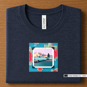 Heather Midnight Navy colored folded t-shirt with a vintage photo of two classic 50's cars on the street. Photo is surrounded by floral fabric.