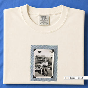 Ivory colored folded t-shirt with a small vintage photo of a father and his son sitting on the bumper of an old car.