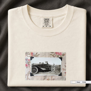 Ivory colored folded t-shirt with small vintage snapshot of people riding in a 1920's car surrounded by a floral design.