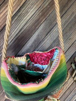 Interior view of a handmade basket shoulder bag with a Mexican blanket textile and natural fiber floral detail.