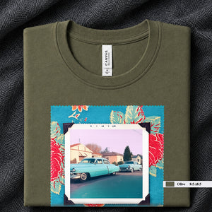 Olive colored folded t-shirt with large a vintage photo of two classic 50's cars on the street. Photo is surrounded by floral fabric.