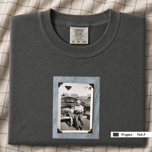 Pepper colored folded t-shirt with a small vintage photo of a father and his son sitting on the bumper of an old car.