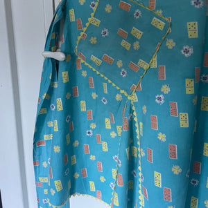 Ricrac trim shown on pockets of a vintage domino print apron