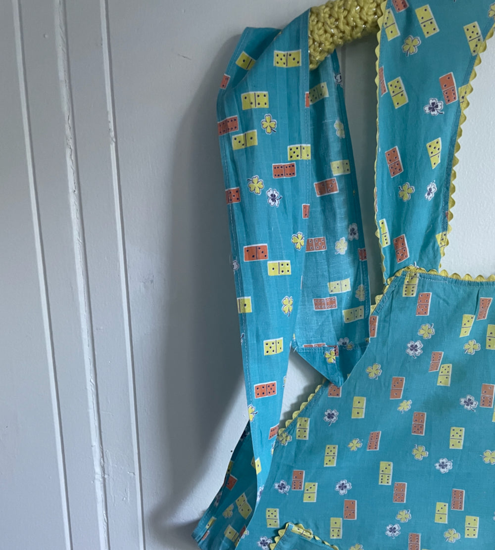 Vintage full length domino blue 50s apron with yellow ricrac trim.