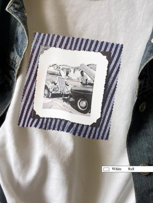 A white  t-shirt with a vintage photo of two guys fixing old trucks