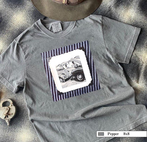 A grey t-shirt with a vintage photo of two guys fixing old trucks