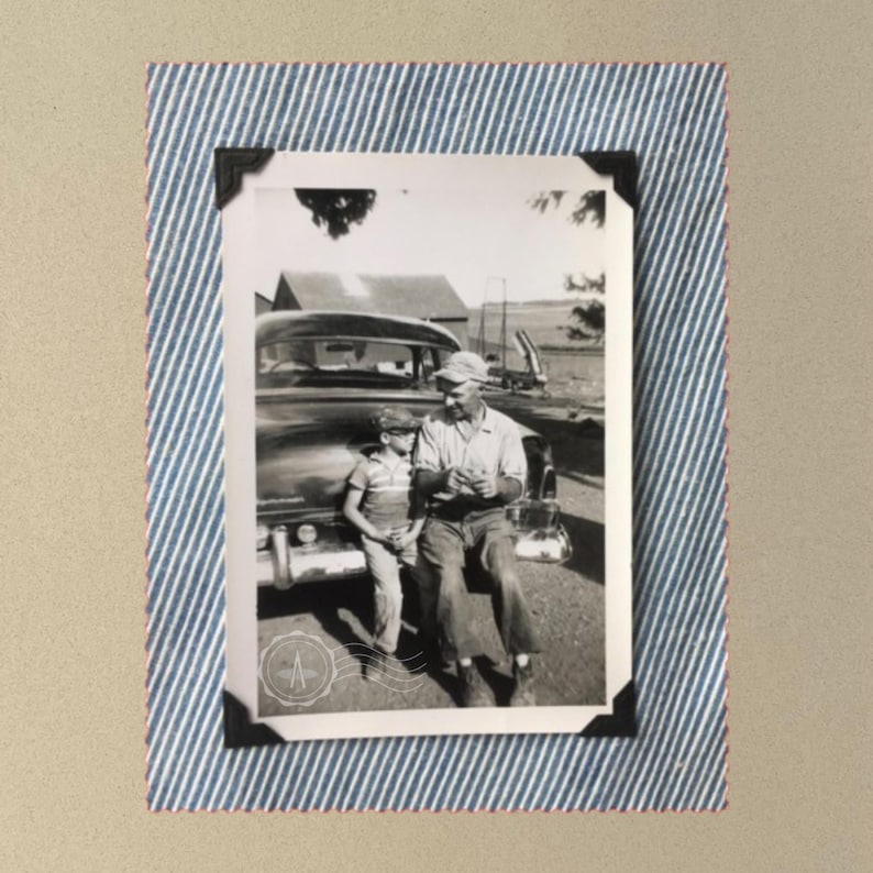 Grey t-shirt with large vintage photo of a boy and his son sitting on the bumper of an old car