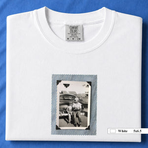 White colored folded t-shirt with a small vintage photo of a father and his son sitting on the bumper of an old car.