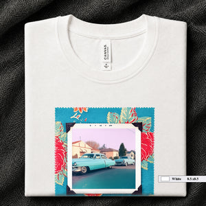 White colored folded t-shirt with large a vintage photo of two classic 50's cars on the street. Photo is surrounded by floral fabric.