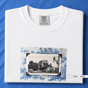 White folded tshirt with large vintage photo of kids playing in trees on front of shirt