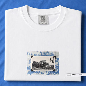 white folded tshirt with small vintage photo of kids playing in trees on front of shirt