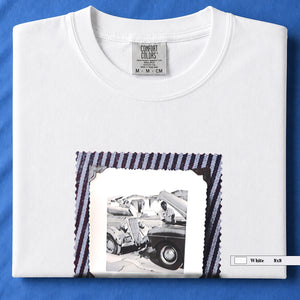 White t-shirt with a large vintage photo of mechanics and cars on front of shirt.