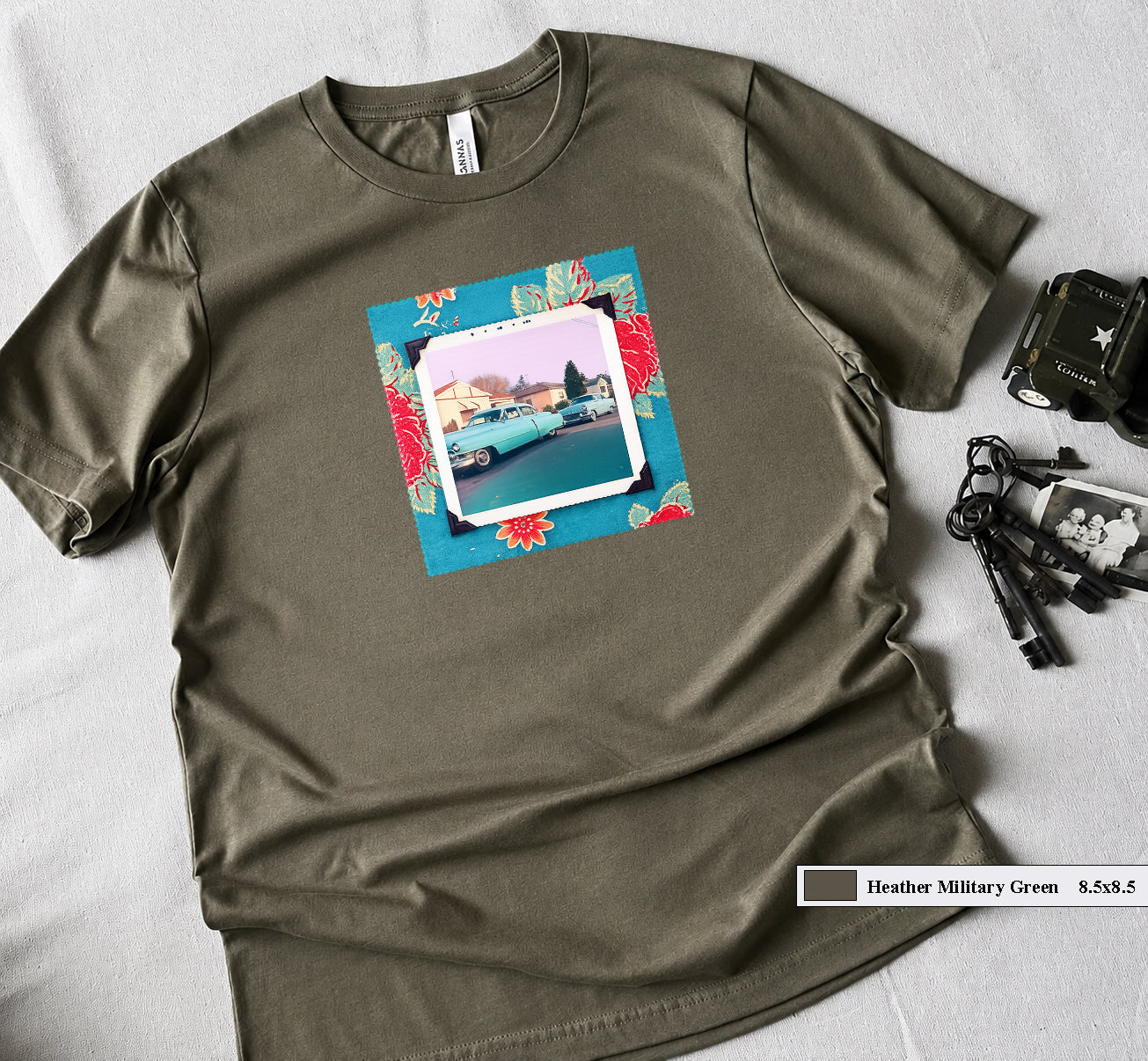 A t-shirt with a patch on the front of a vintage photo of two classic 50's cars framed in a floral fabric.