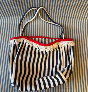 navy and white striped tote bag with white fringe flat lay