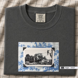 Charcoal colored folded tshirt with large vintage photo of kids playing in trees on front of shirt