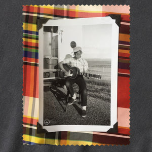 black and white photo of guitar player framed in colorful plaid 