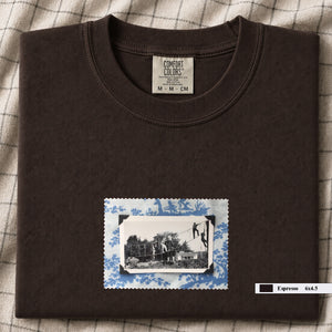 Dark brown colored folded tshirt with small vintage photo of kids playing in trees on front of shirt