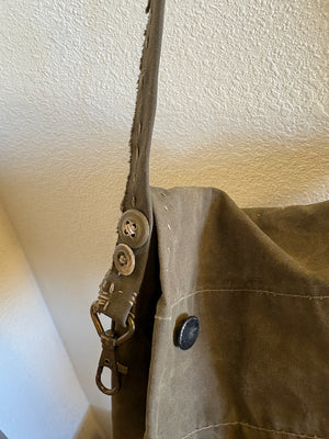 Details of a handmade strap with a utility clip on an army tent bag