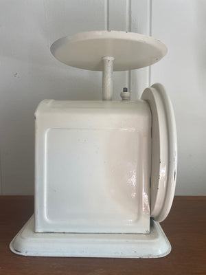 A side shot of a vintage Chatillion dietary scale with white finish and decorative design.