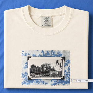 Ivory colored folded tshirt with large vintage photo of kids playing in trees on front of shirt