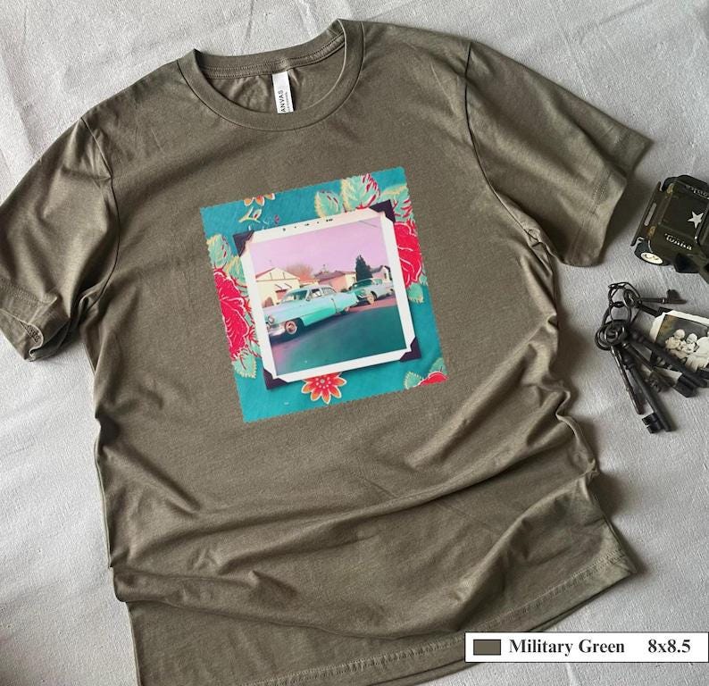 A t-shirt with a vintage photo of two classic 50's carand photo is surrounded by floral fabric.