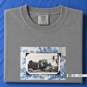 Light grey colored folded tshirt with large vintage photo of kids playing in trees on front of shirt