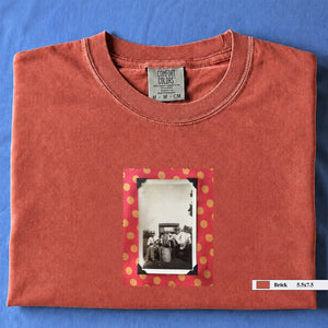 Orange colored folded t-shirt with vintage photo of musicians playing