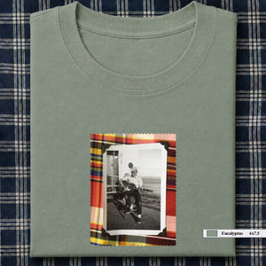 sage green folded tee shirt with small vintage photo of guitar player on front