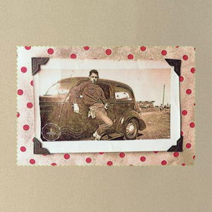 A vintage 1930's snapshot of a boy and his holster in front of an old car.