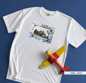 White t-shirt on table with large vintage photo of kids playing on front of shirt