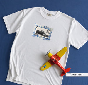 White t-shirt on table with small vintage photo of kids playing on front of shirt