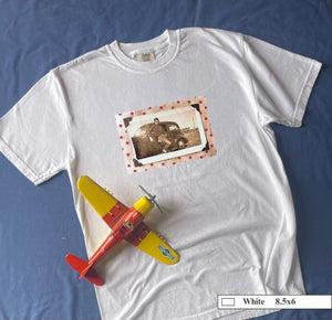 A white t-shirt with a polka dot framed vintage photo of a boy and his holster in front of an old car