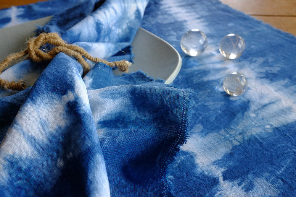 Handmade indigo tie-dyed linen napkins with unique designs.