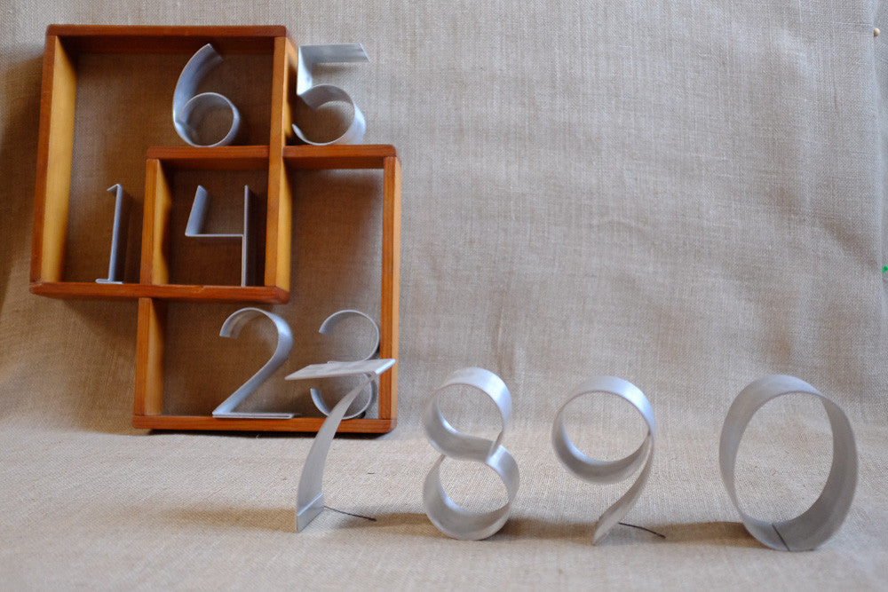 Bent aluminum numbers for decorative wall art and unique displays.