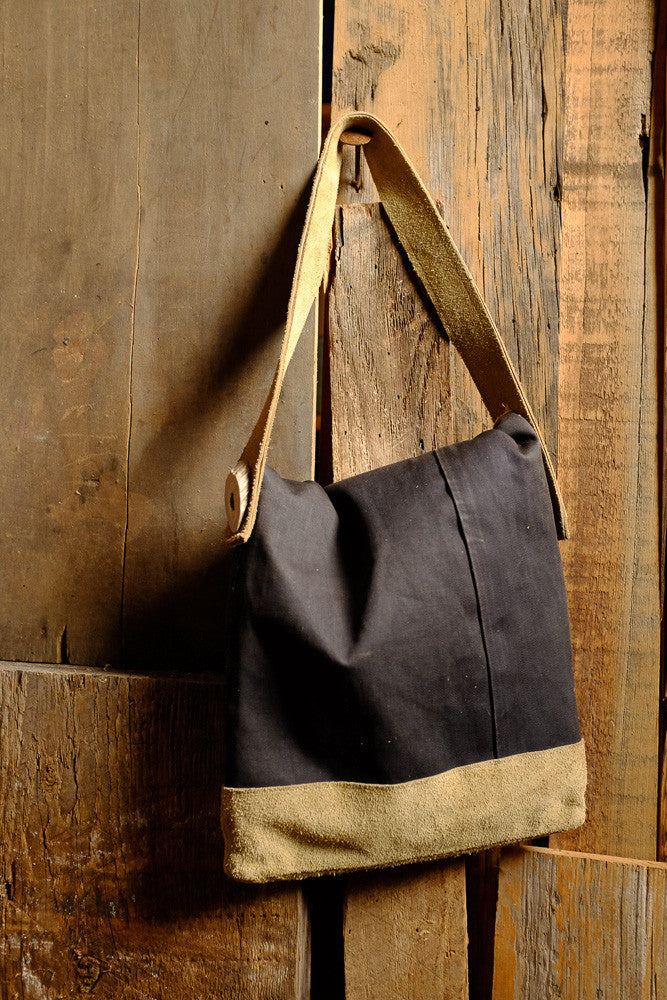 Canvas and suede shoulder bag for tablet storage and outdoor use.